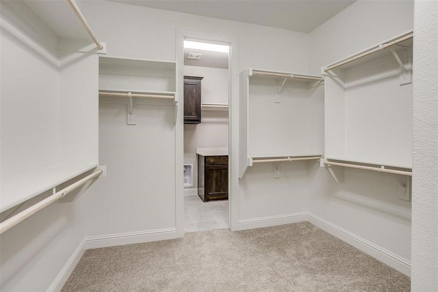 Walk in closet featuring light colored carpet