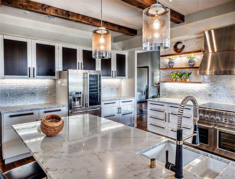 Kitchen featuring a sink, beam ceiling, stainless steel appliances, wall chimney exhaust hood, and open shelves