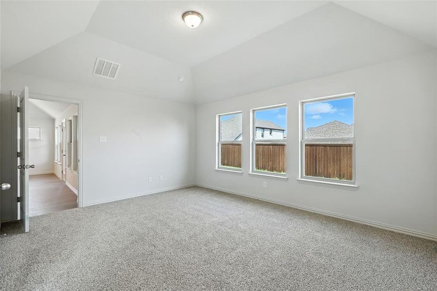 Unfurnished bedroom with carpet and vaulted ceiling Unfurnished bedroom with carpet and vaulted ceiling