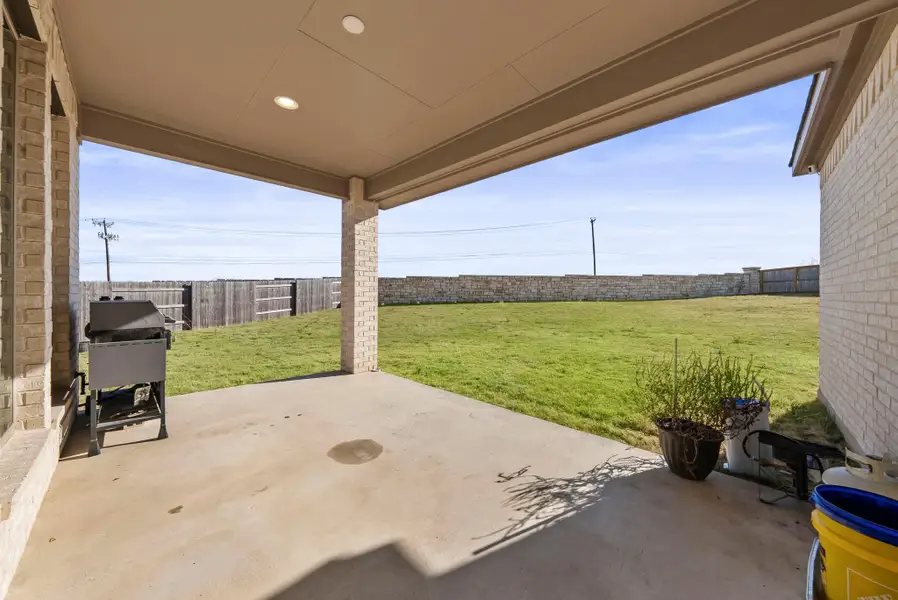 Fenced backyard with a patio area and grilling area