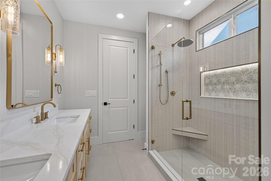 You guested it...illuminated shower niche! Not pictured linen closet. Look at those scones! Dual sink vanities, Calcutta quartz, champagne bronze lighting and fixtures, porcelain tile flooring, rainwater & hand held shower heads, recessed lighting.