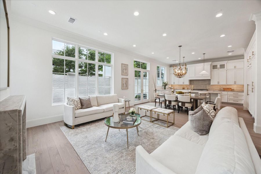 The stunning first floor was designed with relaxation and entertaining in mind! Spacious enough for ample seating surrounding the fireplace, a large dining table, and an island with additional seating that overlooks the living space. **Photo is of another home in the community and for information purposes only. Buyer to verify all details.** The stunning first floor was designed with relaxation and entertaining in mind! Spacious enough for ample seating surrounding the fireplace, a large dining table, and an island with additional seating that overlooks the living space. **Photo is of another home in the community and for information purposes only. Buyer to verify all details.**