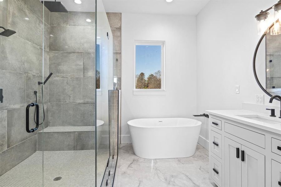 Full bath featuring a shower stall, a freestanding tub, vanity, and marble finish floor Full bath featuring a shower stall, a freestanding tub, vanity, and marble finish floor