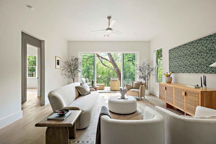 Living room featuring baseboards, light wood-type flooring, and ceiling fan