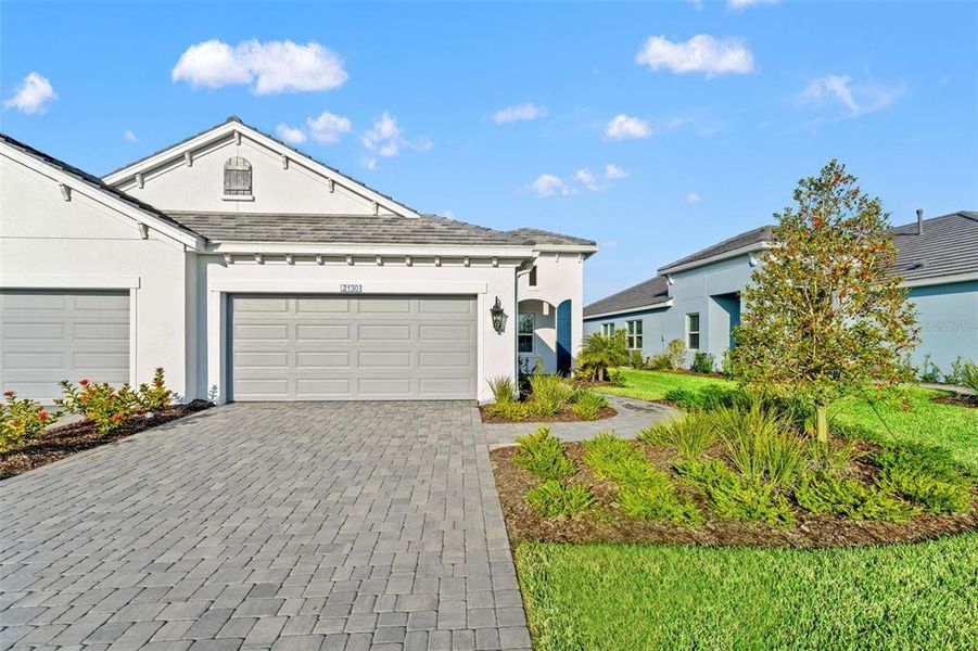 Front exterior of a new home in Palm Grove, Lakewood Ranch, FL, highlighting curb appeal (Image 25). Front exterior of a new home in Palm Grove, Lakewood Ranch, FL, highlighting curb appeal (Image 25).