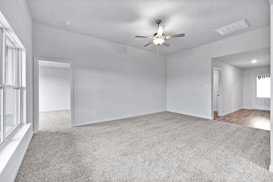 Unfurnished room featuring light colored carpet and ceiling fan