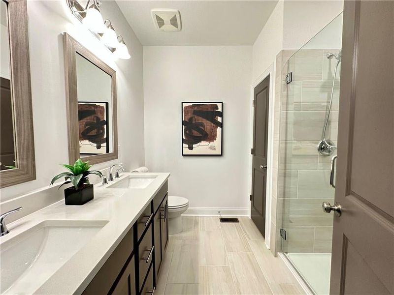 Bathroom with a shower stall, tile patterned floors, double vanity, and Linen Closet *Photos Showcase Warm Wheat Design Collection from a different Staged Model Home Site*