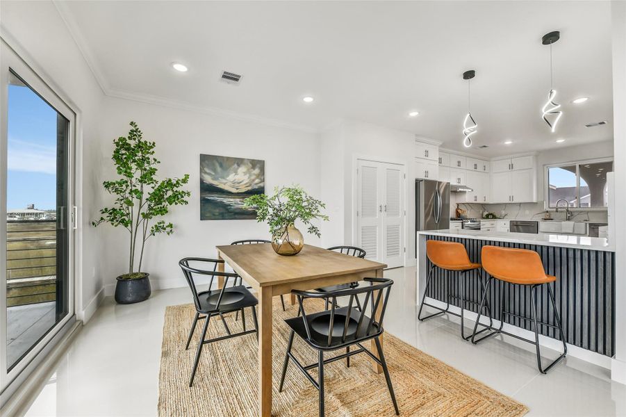 The open plan makes hosting feel natural. Guests can move easily from the kitchen and dining area to the covered porch while the bay remains the backdrop. The open plan makes hosting feel natural. Guests can move easily from the kitchen and dining area to the covered porch while the bay remains the backdrop.