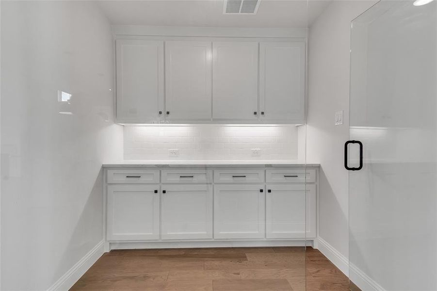 Laundry area with light hardwood / wood-style floors