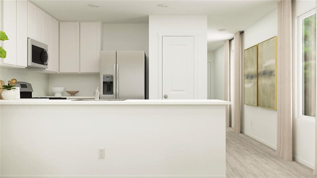 Kitchen featuring fridge with ice dispenser, white cabinetry, sink, light hardwood / wood-style flooring, and range