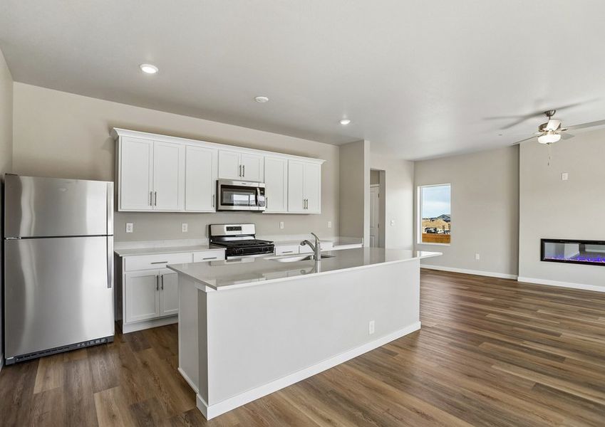 The kitchen has stainless steel appliances and plank flooring.