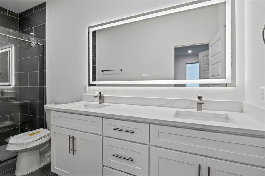 Bathroom with vanity, toilet, and a tile shower