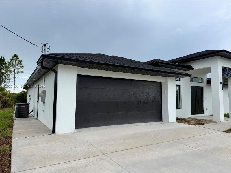 Front exterior of a new home in , Lehigh Acres, FL, highlighting curb appeal (Image 26).