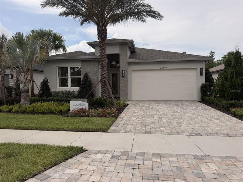 Front exterior of a new home in Valencia Ridge (55+), Wesley Chapel, FL, highlighting curb appeal (Image 2).