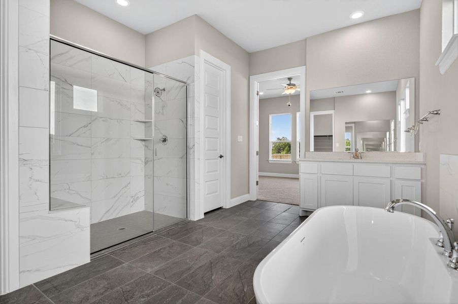 Bathroom with a freestanding tub, vanity, a marble finish shower, ceiling fan, and recessed lighting