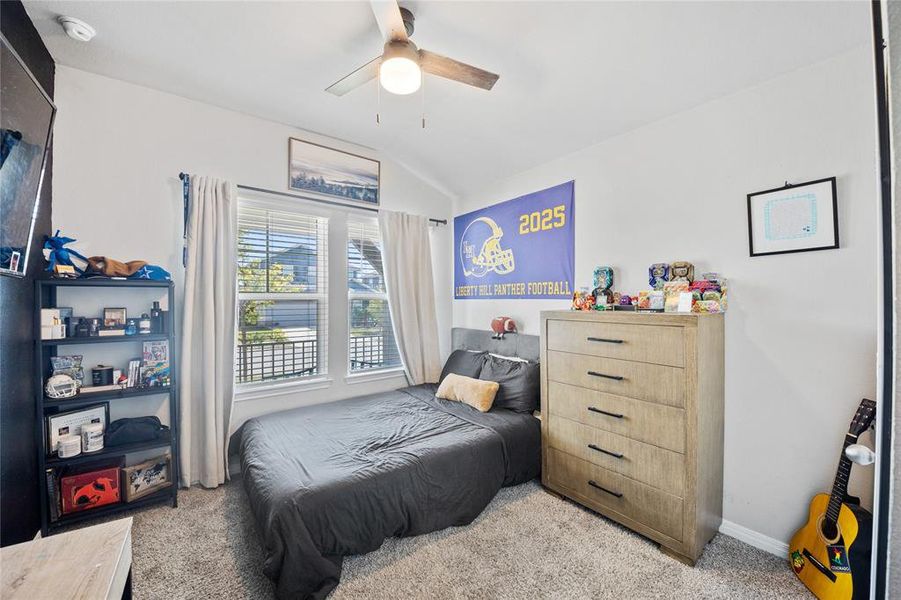 Bedroom with light carpet, lofted ceiling, and ceiling fan