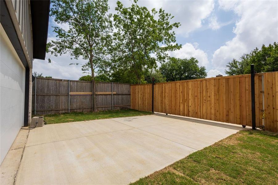 Fenced backyard featuring electric gate