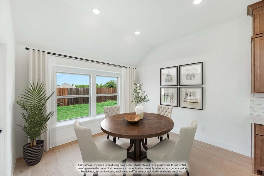 Dining area with round wood table, tufted chairs, vaulted ceiling, and large window overlooking backyard Dining area with round wood table, tufted chairs, vaulted ceiling, and large window overlooking backyard
