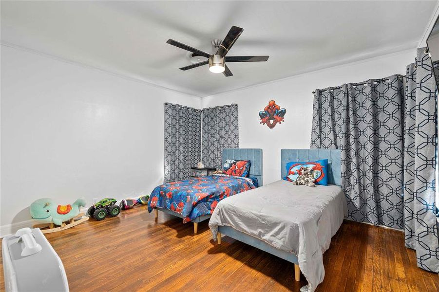 Bedroom featuring hardwood / wood-style flooring and a ceiling fan Bedroom featuring hardwood / wood-style flooring and a ceiling fan