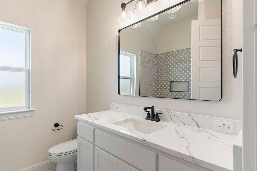 Bathroom with vanity and tiled shower