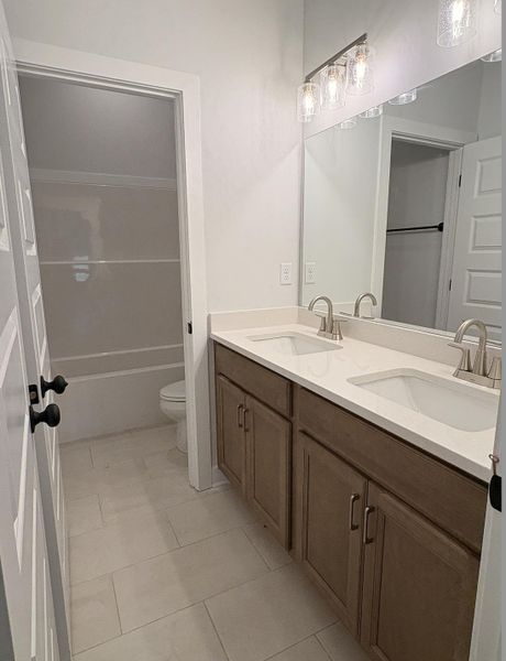 Dual vanity with brushed nickel fixtures, under-mount sinks, and light-toned cabinetry