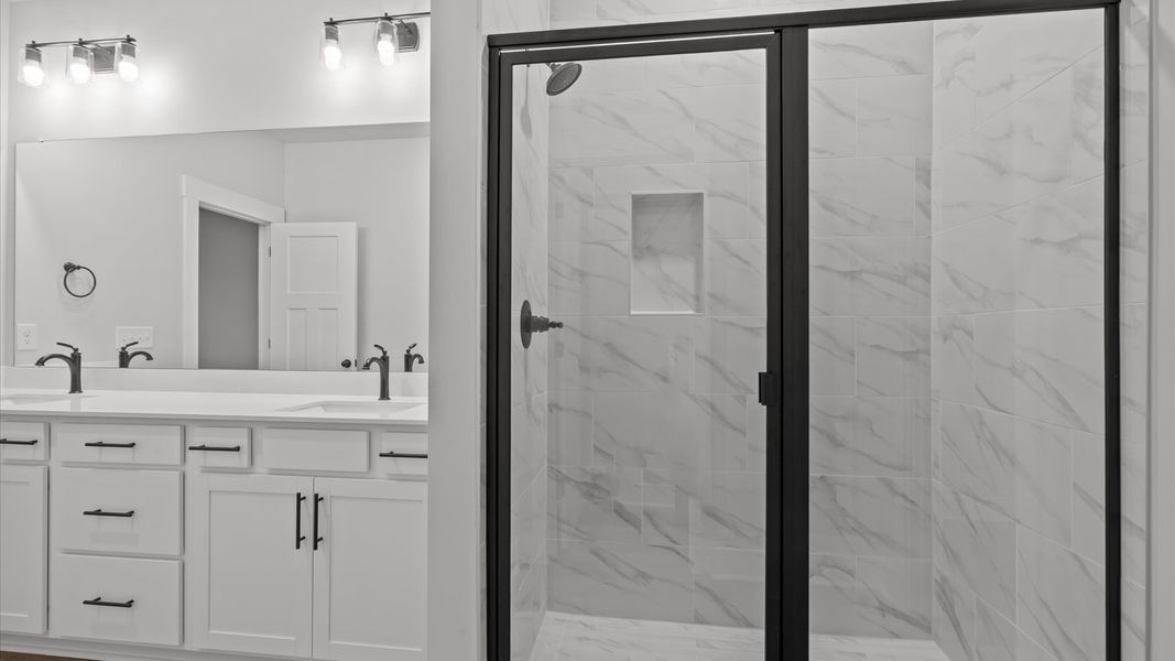 Superior en-suite primary bathroom with stylish dual vanity and tiled walk-in shower crafted with high standards in mind Superior en-suite primary bathroom with stylish dual vanity and tiled walk-in shower crafted with high standards in mind