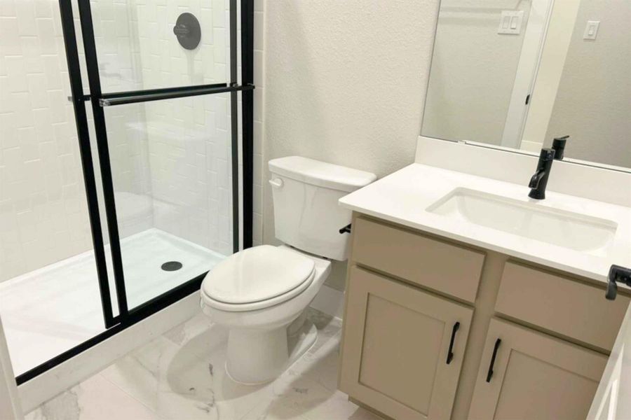 Bathroom with vanity, a stall shower, a textured wall, and light marble finish floors