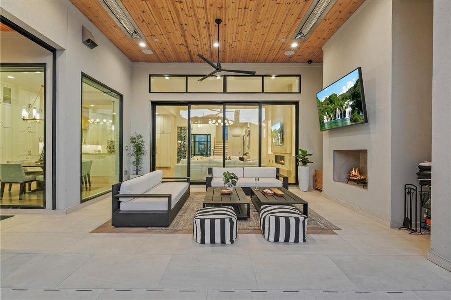 View of patio / terrace featuring an outdoor living space with a fireplace and a ceiling fan View of patio / terrace featuring an outdoor living space with a fireplace and a ceiling fan