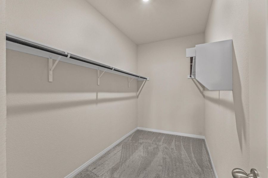 Walk in closet featuring light colored carpet Walk in closet featuring light colored carpet