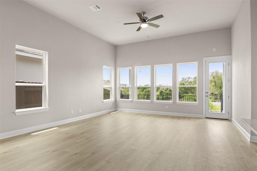 Unfurnished room featuring light wood-type flooring, baseboards, and a ceiling fan