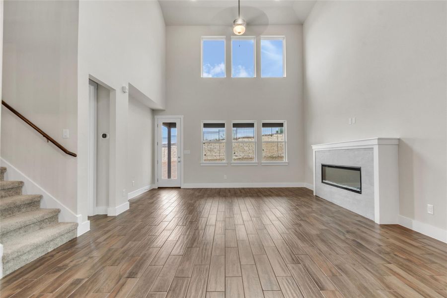 A spacious living area features high ceilings, a contemporary fireplace, and abundant natural light.