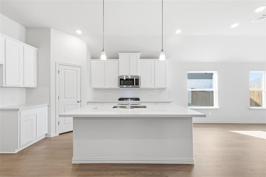 Kitchen featuring white cabinets, tasteful backsplash, a center island with sink, and recessed lighting Kitchen featuring white cabinets, tasteful backsplash, a center island with sink, and recessed lighting