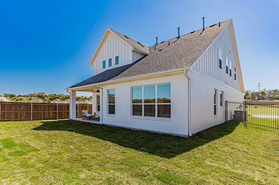 Back of house with a patio area, central air condition unit, and a lawn