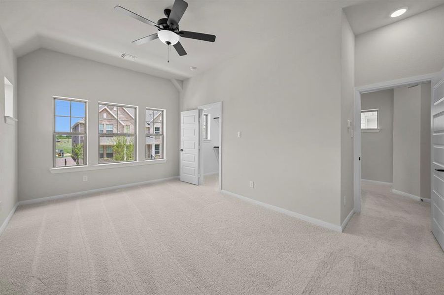 Unfurnished bedroom featuring light carpet, a ceiling fan, and lofted ceiling