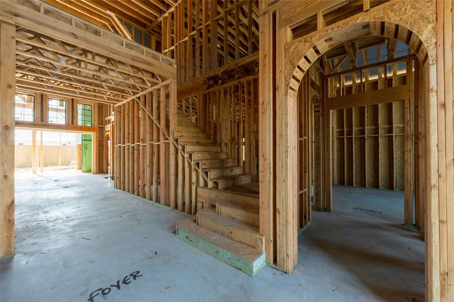 The foyer unfolds with intention arched transitions and ascending lines creating a layered composition that hints at the elegance to come.