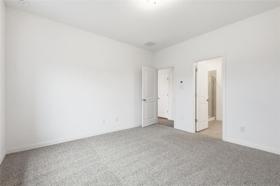 Unfurnished bedroom with light carpet and baseboards
