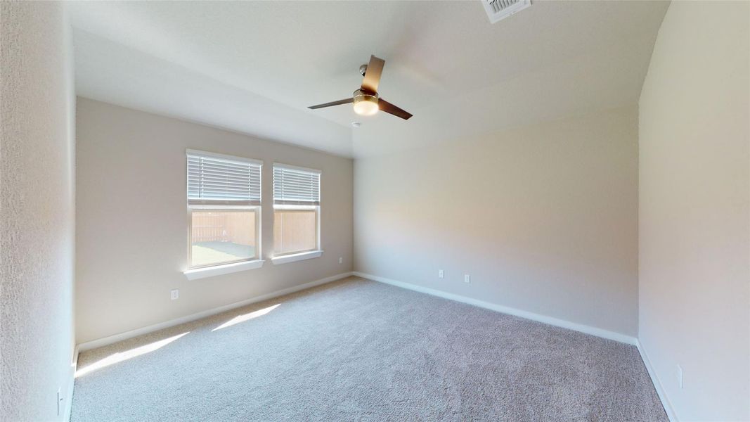 A spacious bedroom provides a blank canvas, complete with a ceiling fan and abundant natural illumination. A spacious bedroom provides a blank canvas, complete with a ceiling fan and abundant natural illumination.