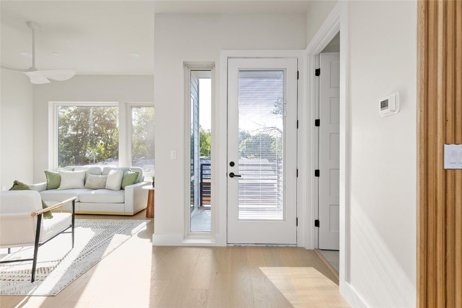 Natural light pours across the entryway and into the adjacent open living area.