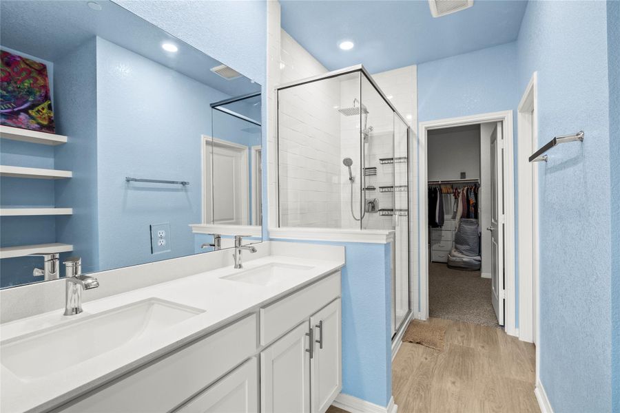 Double vanity and a modern glass-enclosed shower create a refined and functional bathroom space.