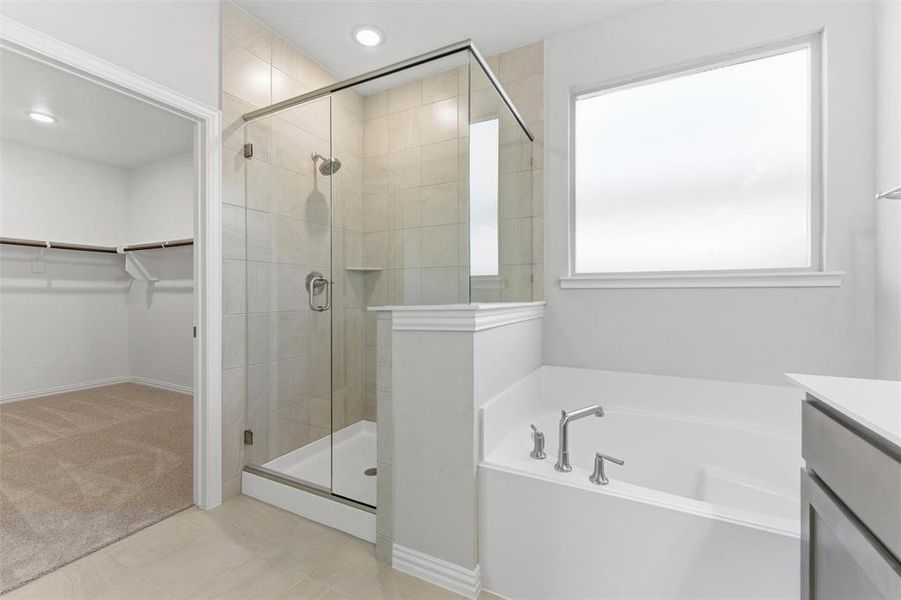 Full bathroom featuring a spacious closet, a bath, vanity, a shower stall, and recessed lighting