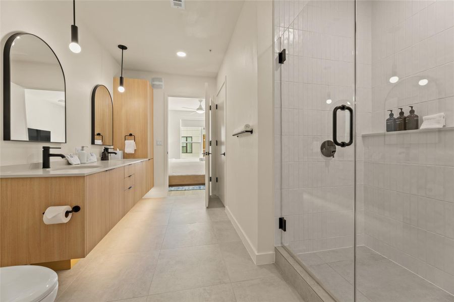 Sleek tile floors and a glass-enclosed shower define this modern bathroom space.