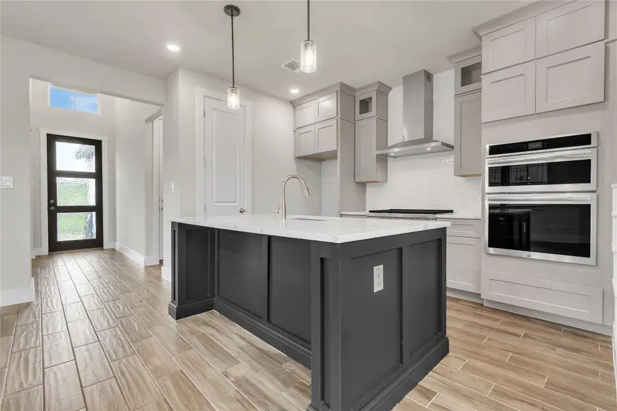 An inviting kitchen features a sleek island and integrated appliances, perfect for culinary adventures.