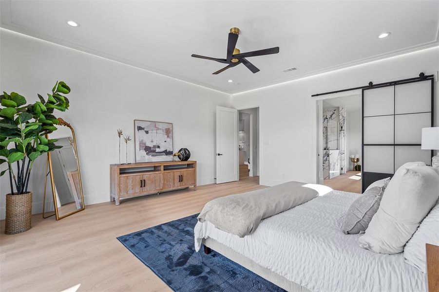 Bedroom with a barn door, light wood-style flooring, recessed lighting, and ceiling fan