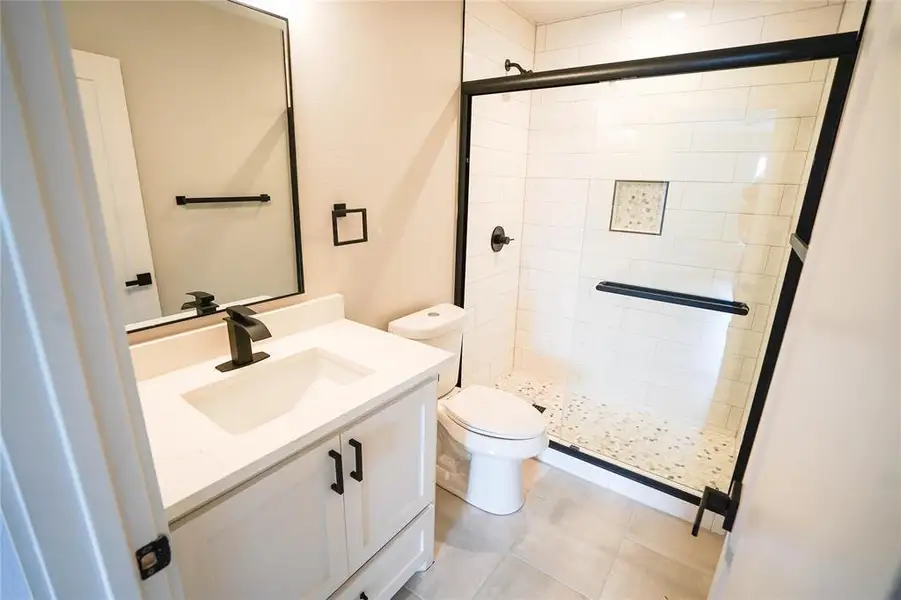 Bathroom featuring vanity, a shower stall, and tile patterned flooring