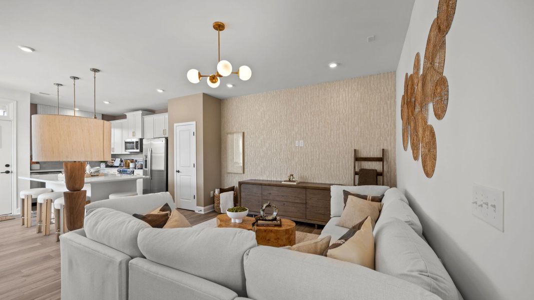 The Rochester Plan by DRB homes living area and kitchen featuring gold modern light fixtures in Charlotte, NC.