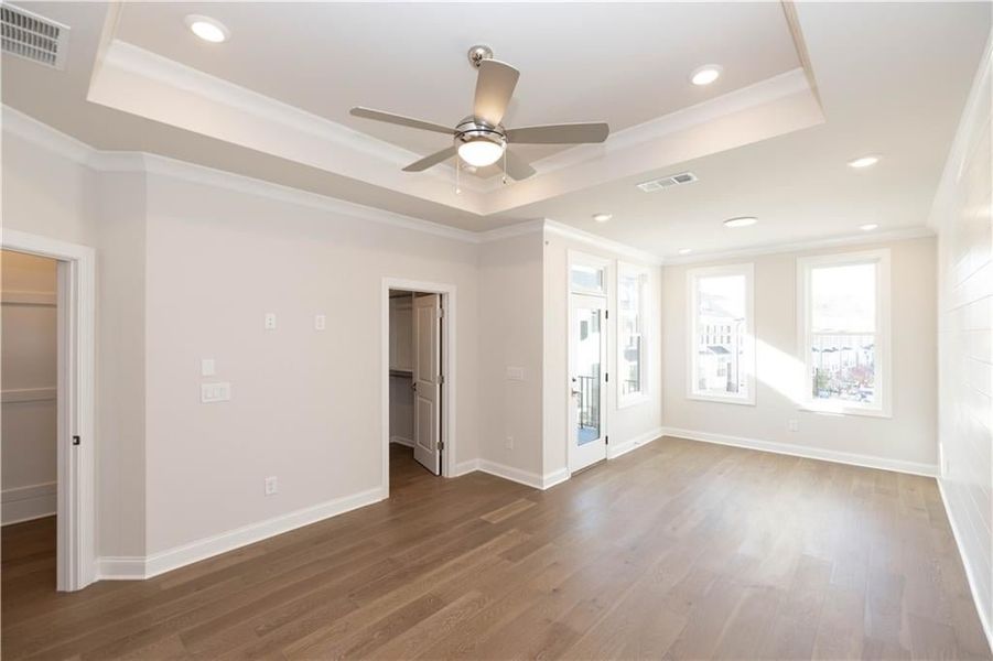 Primary bedroom beams with natural light - enjoy the outdoor space on your private deck off the sitting area. Image is of previously built Chamberlain