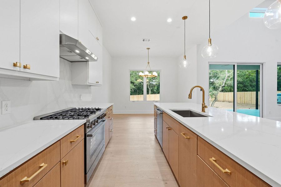 Hardwood floors and quartz countertops anchor this modern culinary space.