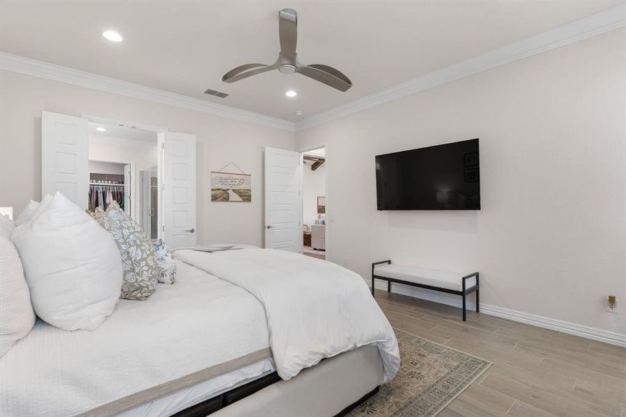 Bedroom featuring wood tiled floors, crown molding, a ceiling fan, and recessed lighting Bedroom featuring wood tiled floors, crown molding, a ceiling fan, and recessed lighting