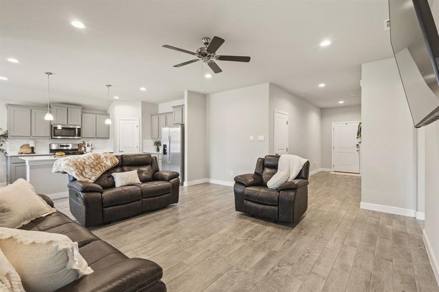 Open-concept living space featuring wood-finish flooring, recessed lighting, and a ceiling fan Open-concept living space featuring wood-finish flooring, recessed lighting, and a ceiling fan