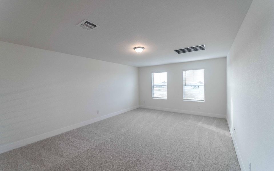 Empty room featuring light carpet and baseboards